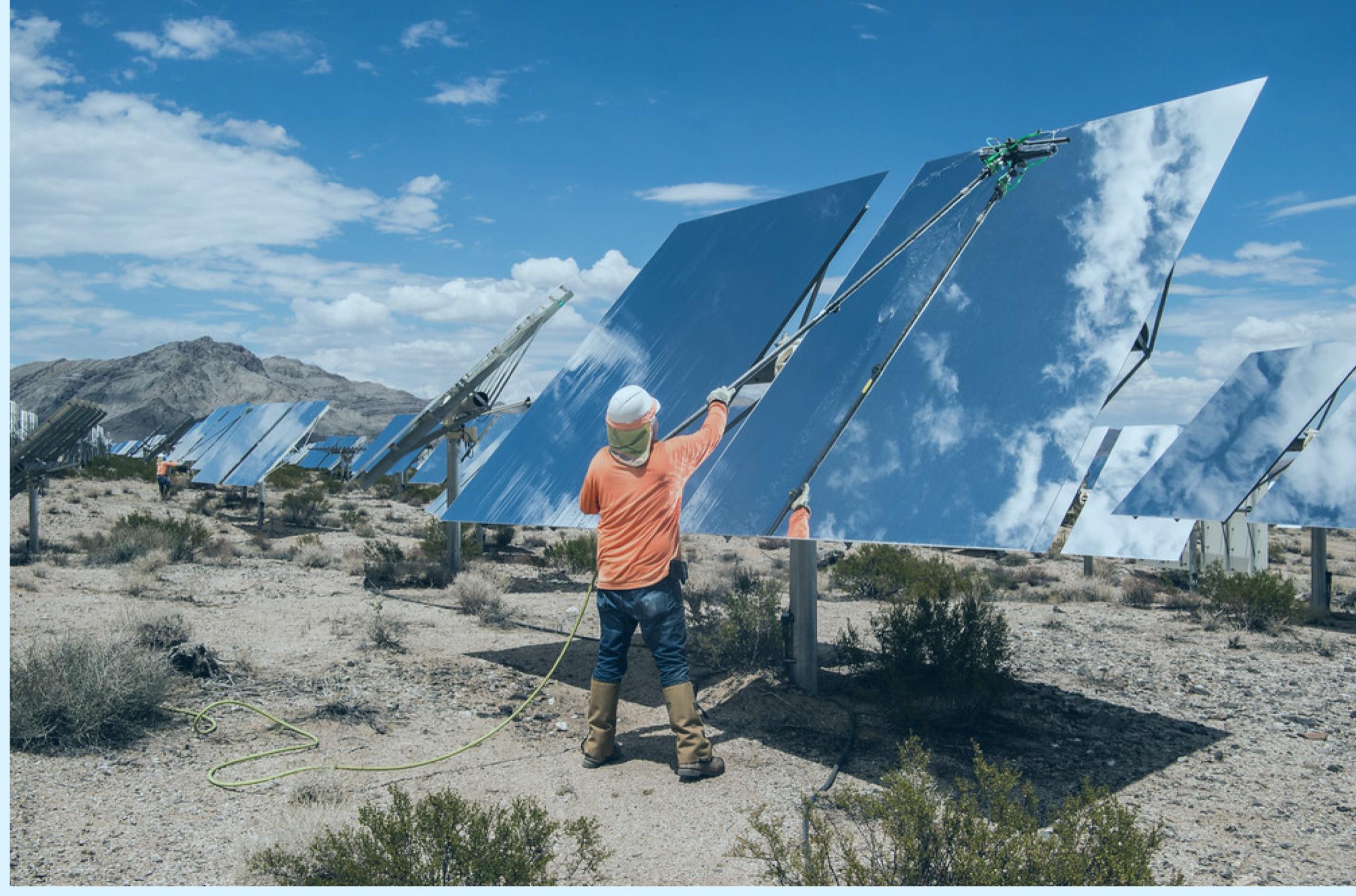 Solar worker cleans solar panels in a desert setting